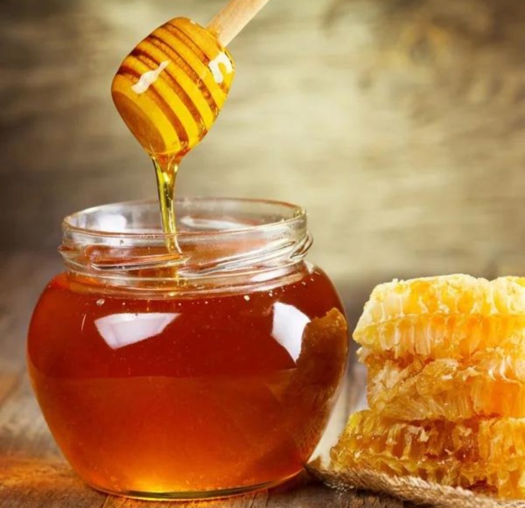 عسل طبیعی و خالص در ظرف شیشه ای همراه با موم
